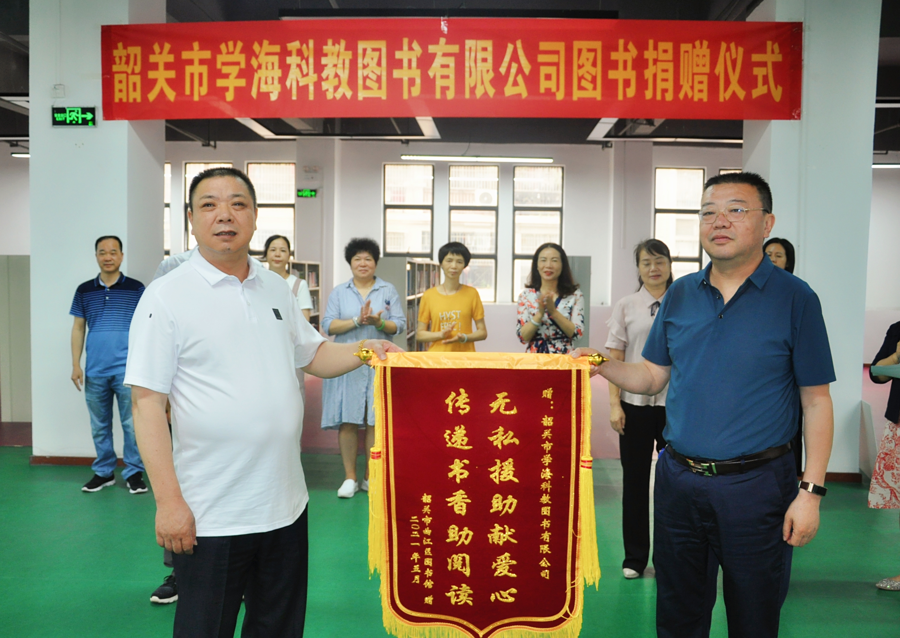 党组副书记李烨为该公司授予"无私援助献爱心,传递书香助阅读"的锦旗